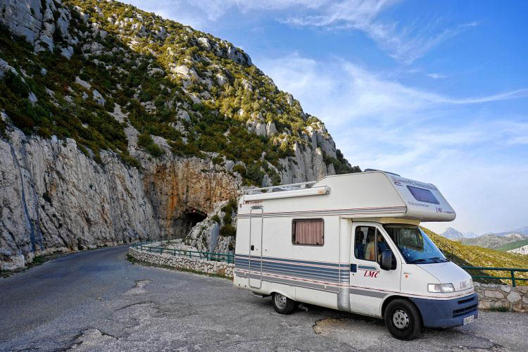 Wohnmobil in Kurve in Berglandschaft